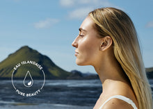 Charger l'image dans la galerie, Femme face à un paysage côtier, illustrant l’eau islandaise et l’univers des soins visage BIOEFFECT.

